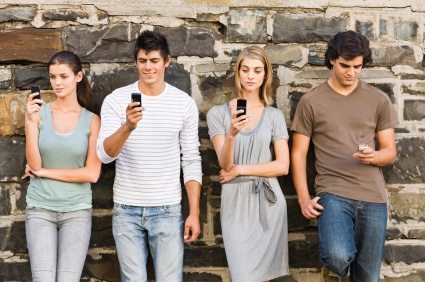Full length of young men and women holding cellphone
